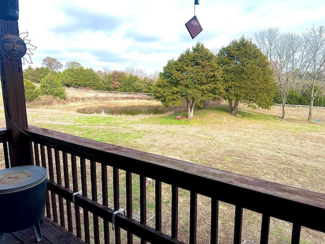 wooden deck with a lawn and a water view