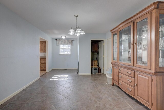 unfurnished dining area featuring light tile patterned floors and a notable chandelier