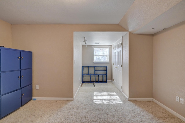 interior space with light colored carpet and a textured ceiling