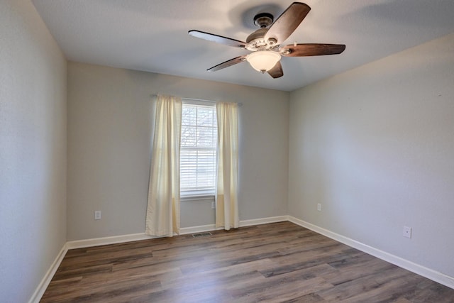 unfurnished room with ceiling fan and dark hardwood / wood-style flooring