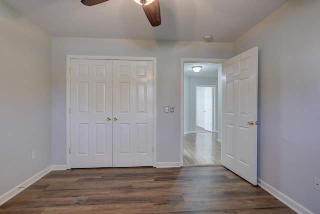 unfurnished bedroom featuring dark hardwood / wood-style flooring, a closet, and ceiling fan