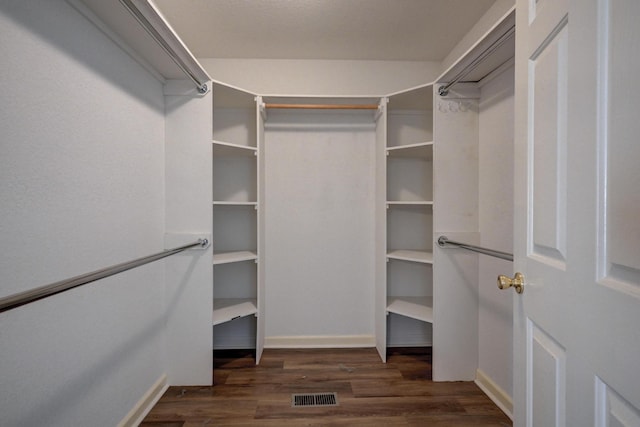 spacious closet featuring dark hardwood / wood-style flooring