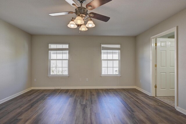 spare room with dark hardwood / wood-style floors, ceiling fan, and a healthy amount of sunlight