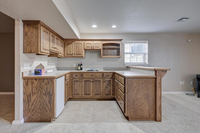 kitchen featuring kitchen peninsula, light carpet, sink, and white dishwasher