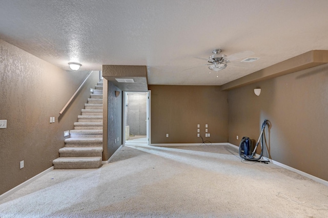 basement featuring ceiling fan, carpet floors, and a textured ceiling