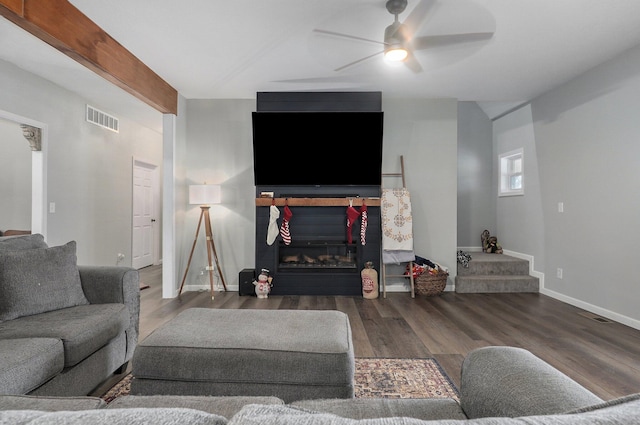 living room featuring ceiling fan and dark wood-type flooring