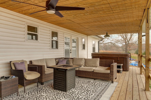 wooden terrace with ceiling fan and an outdoor living space with a fire pit