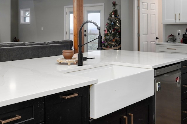 kitchen featuring white cabinets, stainless steel dishwasher, a wealth of natural light, and sink