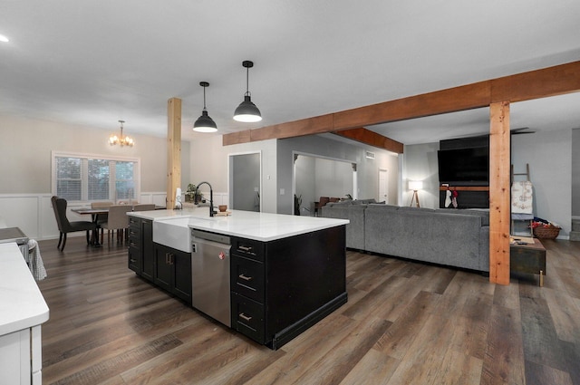 kitchen featuring dark wood-type flooring, sink, pendant lighting, dishwasher, and an island with sink