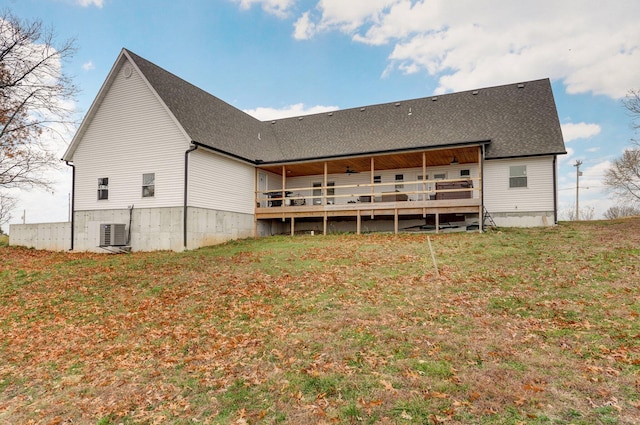 rear view of property featuring central AC unit, a deck, and a yard