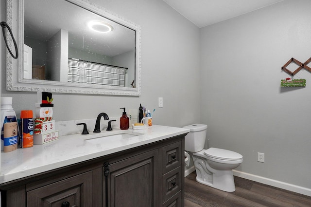 bathroom featuring wood-type flooring, vanity, toilet, and curtained shower