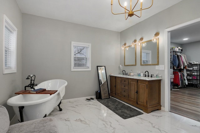 bathroom featuring vanity, hardwood / wood-style flooring, an inviting chandelier, and a bathtub