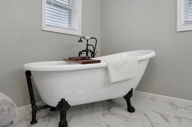 bathroom with plenty of natural light and a bath