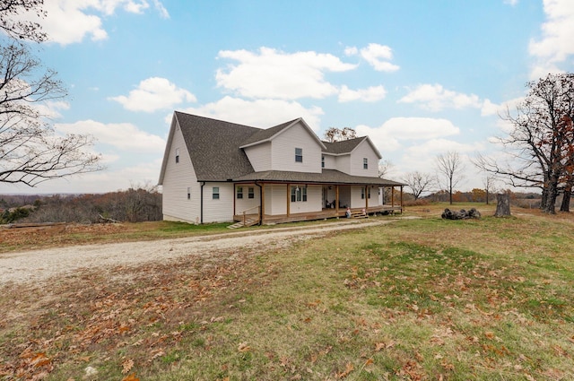 farmhouse featuring covered porch and a front yard