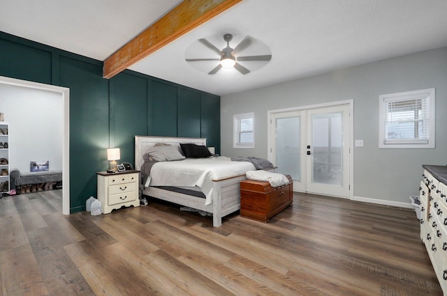 bedroom with multiple windows, ceiling fan, beamed ceiling, and wood-type flooring