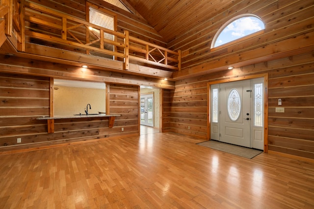 foyer entrance featuring hardwood / wood-style floors, wood walls, wood ceiling, and high vaulted ceiling