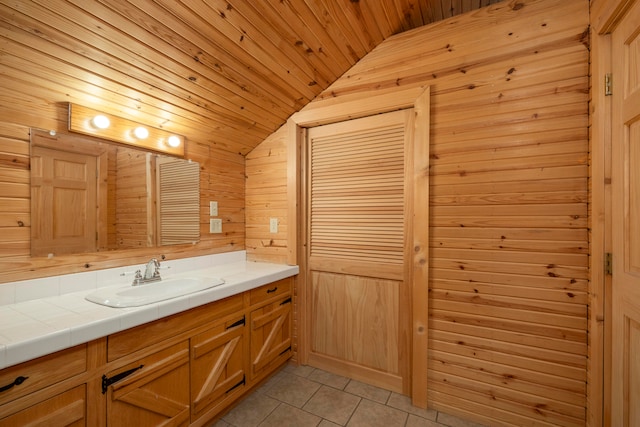 bathroom with tile patterned flooring, lofted ceiling, wooden walls, vanity, and wood ceiling