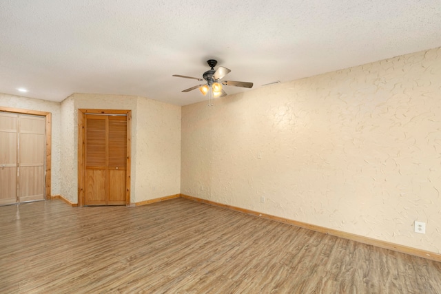 spare room with hardwood / wood-style flooring, ceiling fan, and a textured ceiling