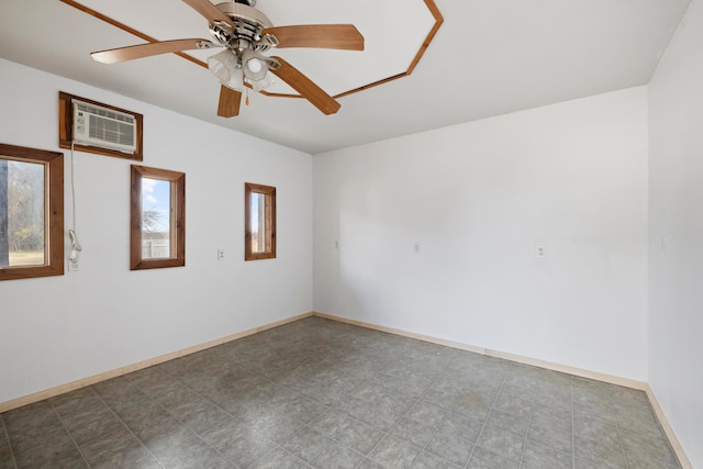 spare room featuring a wall mounted AC and ceiling fan