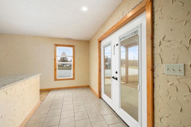 doorway to outside with french doors, a textured ceiling, and light tile patterned flooring