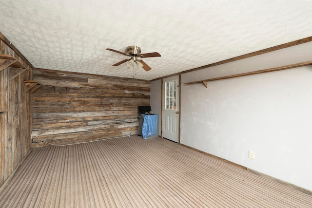 interior space featuring a textured ceiling, ceiling fan, and wooden walls