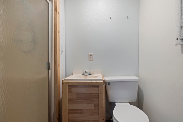 bathroom featuring vanity, toilet, and walk in shower