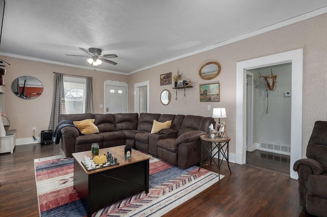 living room with a textured ceiling, dark hardwood / wood-style floors, ceiling fan, and crown molding