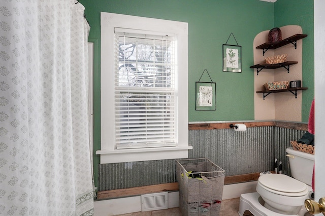 bathroom featuring a shower with curtain and toilet