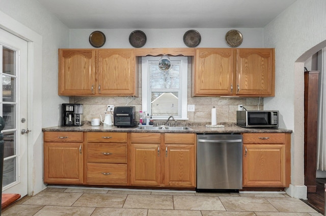 kitchen featuring decorative backsplash, appliances with stainless steel finishes, and sink