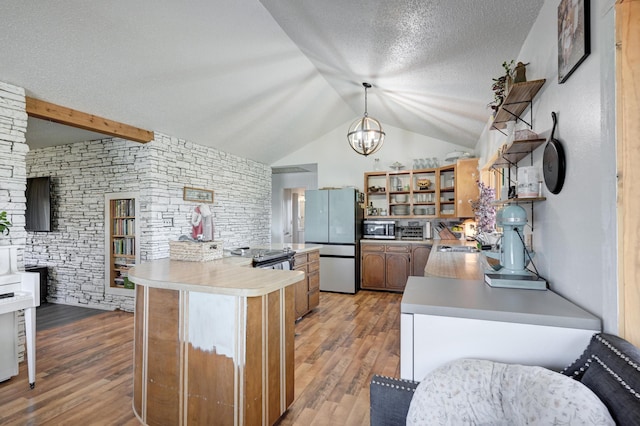 kitchen featuring stainless steel appliances, lofted ceiling with beams, kitchen peninsula, pendant lighting, and light hardwood / wood-style floors