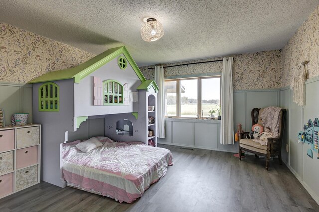 bedroom with hardwood / wood-style floors and a textured ceiling