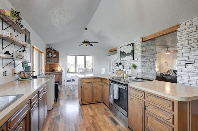 kitchen featuring vaulted ceiling, a textured ceiling, light hardwood / wood-style floors, and stainless steel electric range