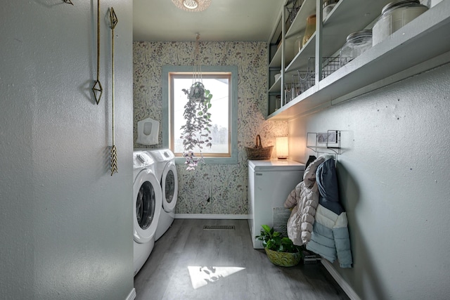 clothes washing area featuring washer and dryer and hardwood / wood-style flooring