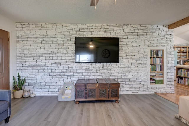 living room featuring wood-type flooring, lofted ceiling with beams, and a textured ceiling