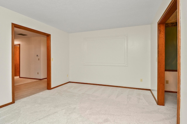 carpeted empty room featuring a textured ceiling