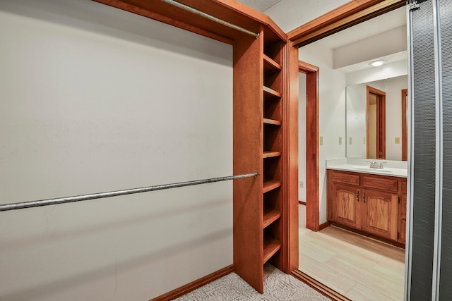 walk in closet featuring sink and light hardwood / wood-style flooring