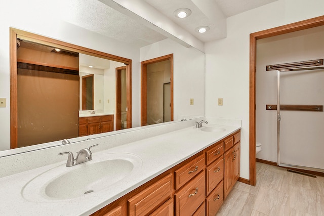 bathroom featuring a textured ceiling, vanity, and toilet