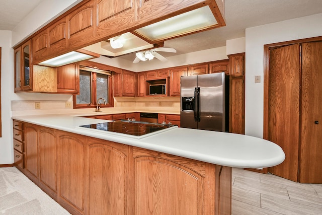 kitchen with ceiling fan, kitchen peninsula, sink, and appliances with stainless steel finishes