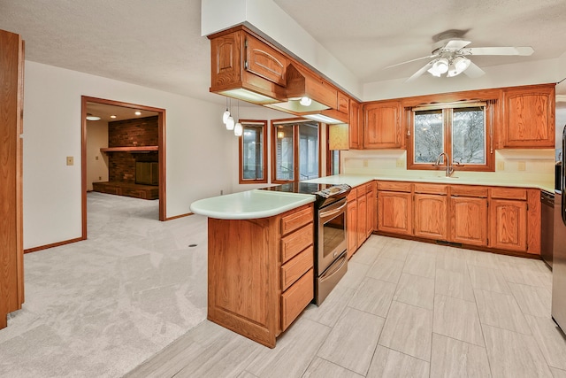 kitchen featuring stainless steel range with electric cooktop, ceiling fan, a textured ceiling, light colored carpet, and kitchen peninsula