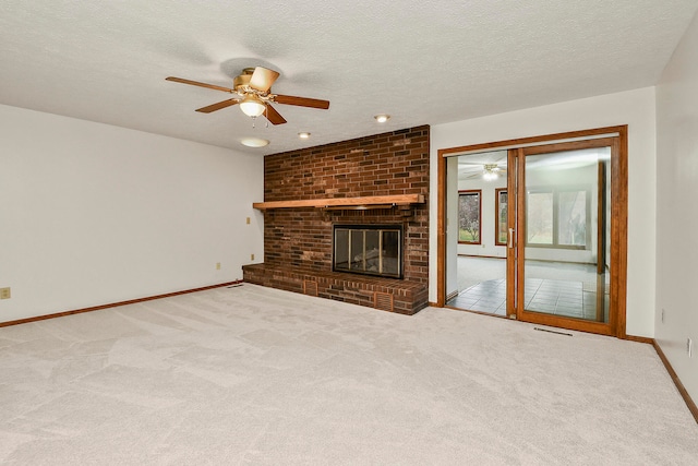 unfurnished living room with carpet, ceiling fan, a fireplace, and a textured ceiling