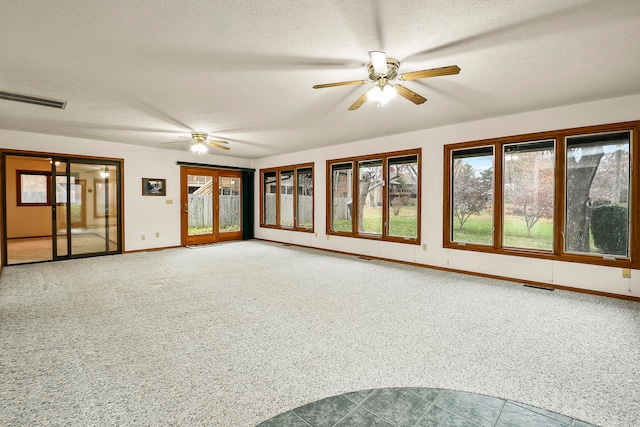 interior space with a textured ceiling, carpet floors, and ceiling fan