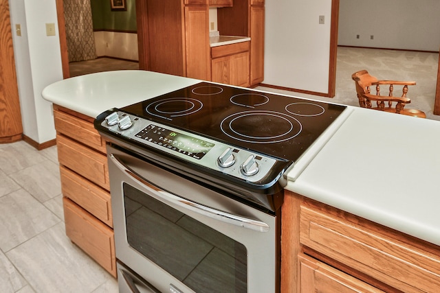 kitchen with light tile patterned flooring and stainless steel electric range