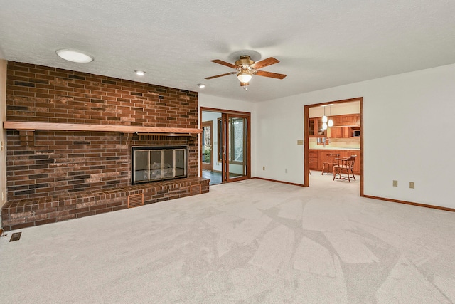 unfurnished living room featuring a textured ceiling, carpet floors, and a fireplace