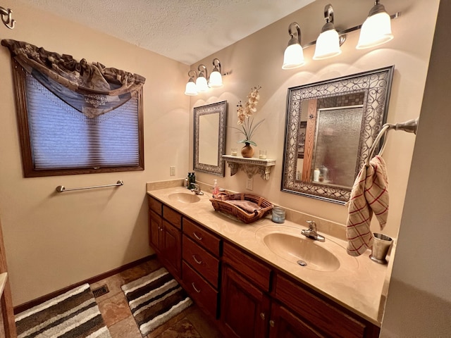 bathroom featuring tile patterned floors, vanity, a shower with shower door, and a textured ceiling