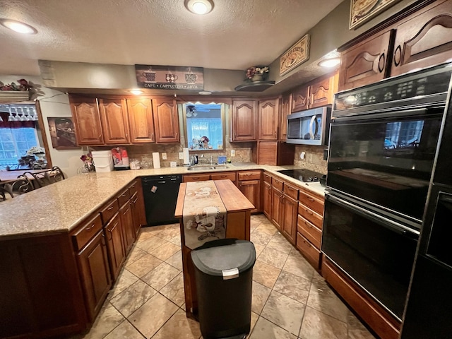 kitchen with black appliances, decorative backsplash, a kitchen island, and sink