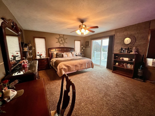 carpeted bedroom featuring access to exterior, ceiling fan, and a textured ceiling