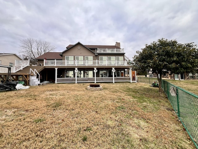 rear view of house featuring a fire pit and a yard