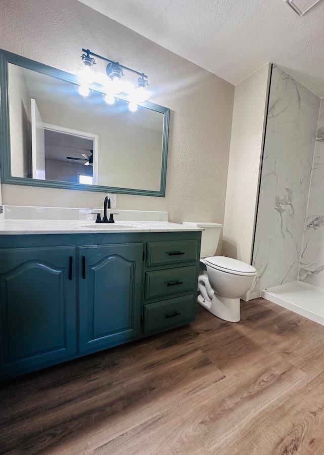 bathroom with vanity, a textured ceiling, a shower, wood-type flooring, and toilet