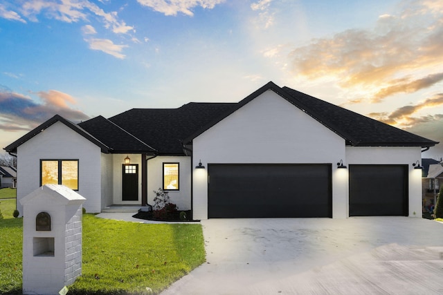 view of front of house with a garage and a yard