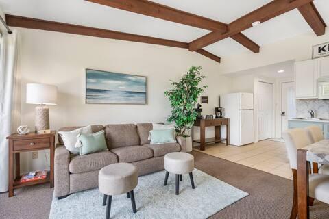 living room featuring sink, lofted ceiling with beams, and light tile patterned flooring